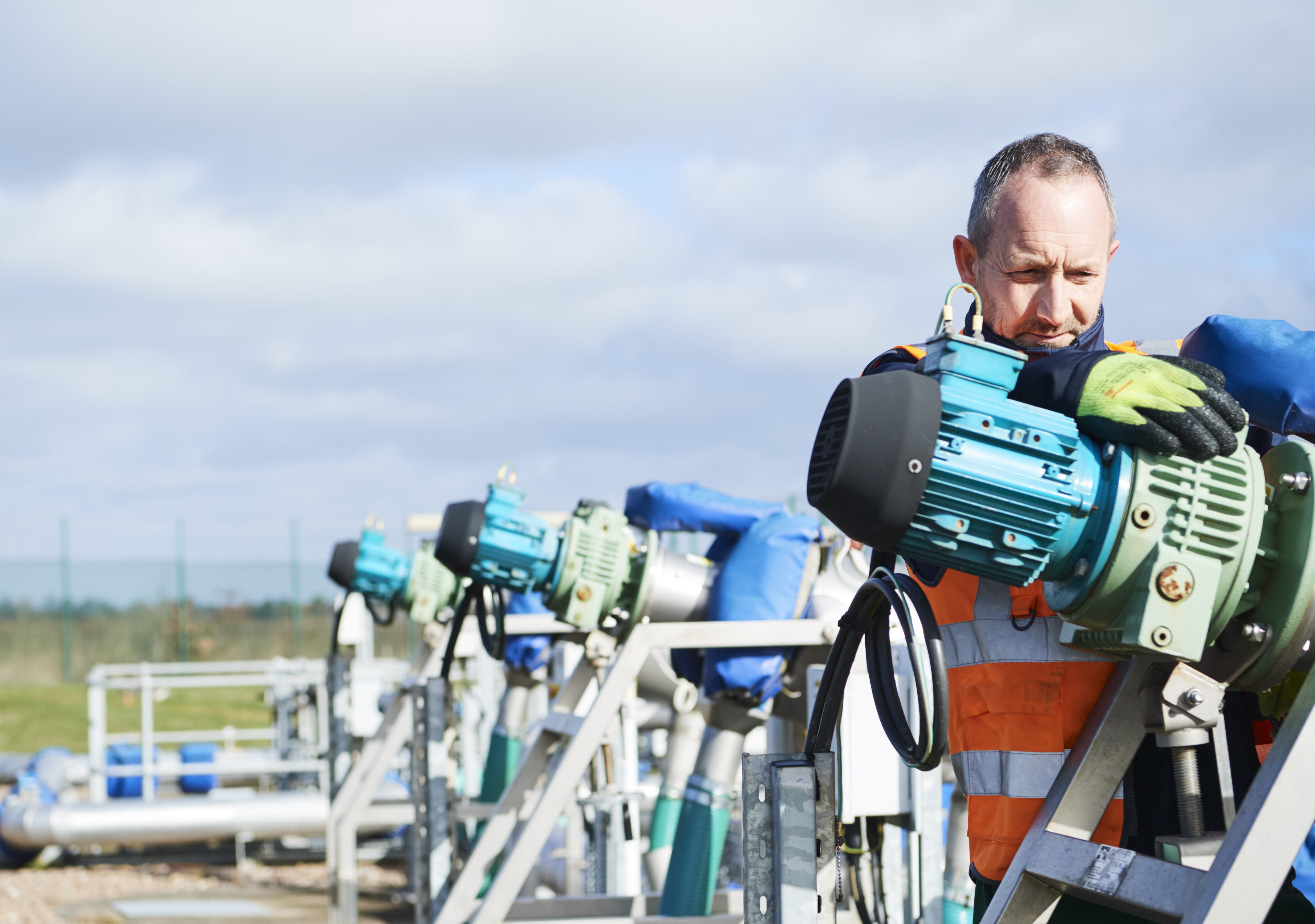 Male in high vis jacket looking at a water cannon device at water treatment centre